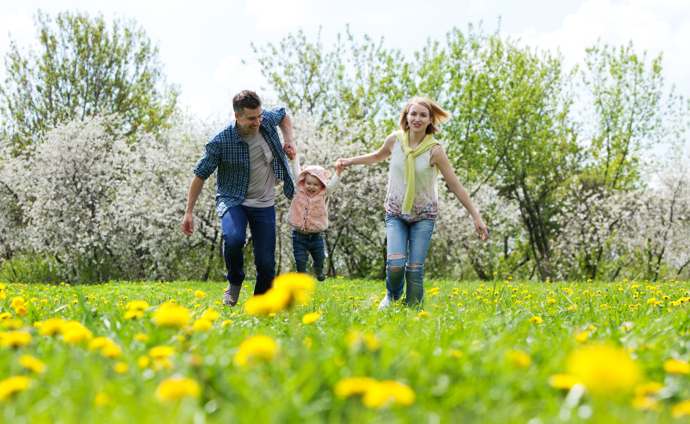 A family skipping and holding hands on a summer day.